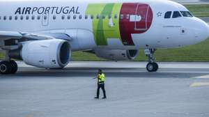 Um trabalhador de placa dá indicações a um piloto num avião da TAP, no Aeroporto Humberto Delgado, em Lisboa, 15 de abril de 2025.  JOSÉ SENA GOULÃO/LUSA
